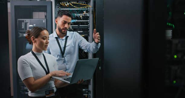 istock Shot of two colleagues working together in a server room 1332104904