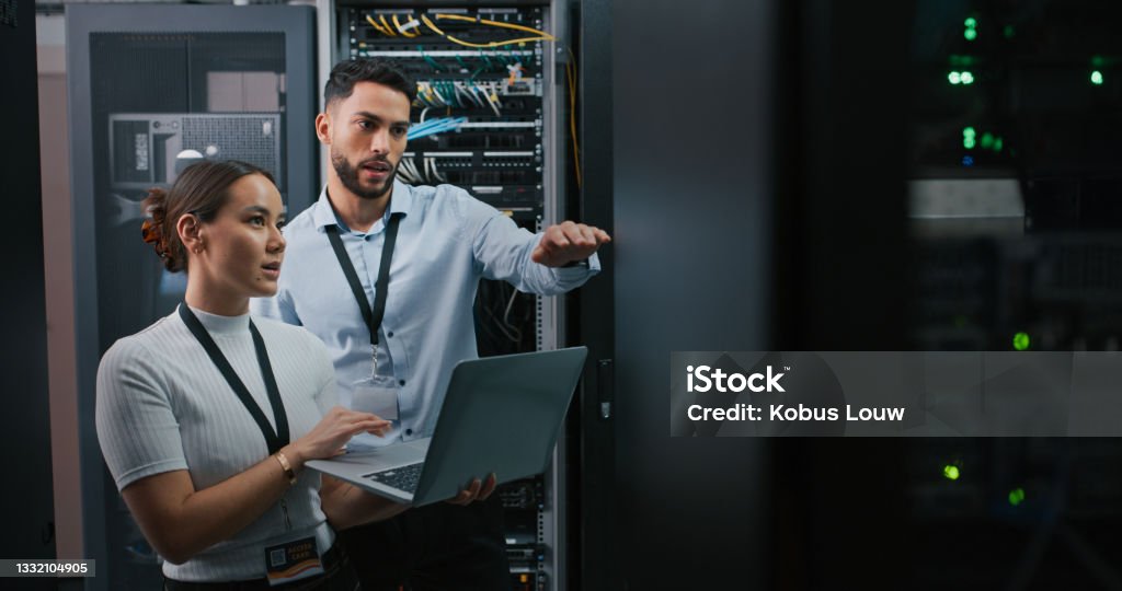 Shot of two colleagues working together in a server room Two minds are better than one Technology Stock Photo