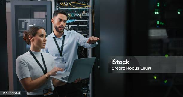 Shot Of Two Colleagues Working Together In A Server Room Stock Photo - Download Image Now