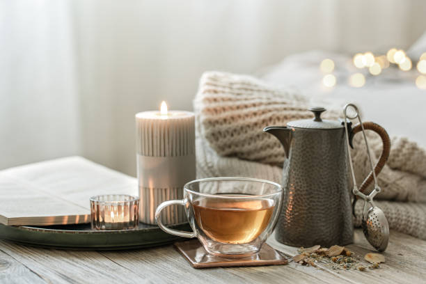 istock Cozy composition with a cup of tea, a teapot and candles. 1332106290