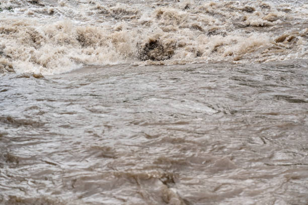 istock Dirty flood water flowing rapidly in river 1332106355