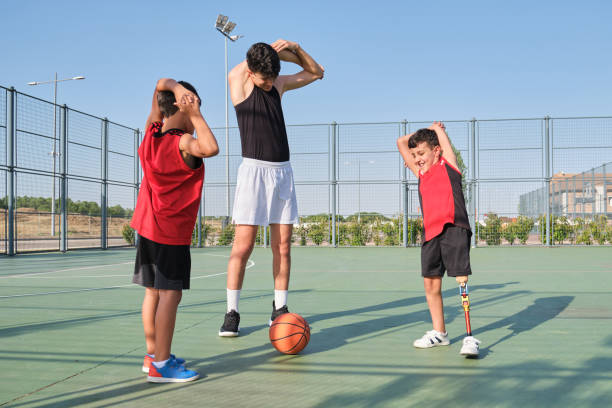 istock Basket coach arm stretching with two children, one has a prosthesis. 1332107736