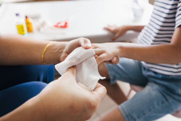 parent helping her child perform first aid finger injury after she has been an accident. - wound blood human finger human hand imagens e fotografias de stock