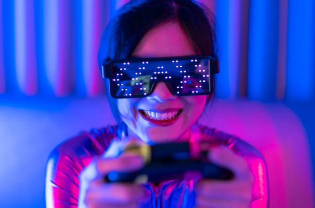 istock Young asian woman is using virtual reality headset. Neon light studio portrait. Concept of virtual reality, simulation, gaming and future technology.Asian woman play game in bedroom. 1332108537