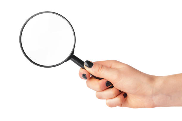 istock Magnifying glass in a woman hand isolated on white background 1332111148