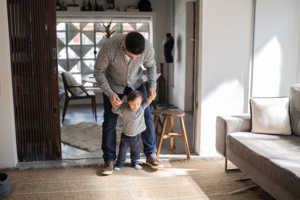 istock Father helping son with special needs taking his firt steps at home 1332111611
