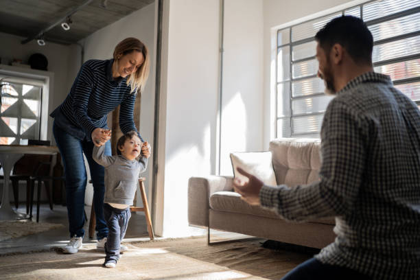 istock Parents helping son with special needs taking his firt steps at home 1332111695