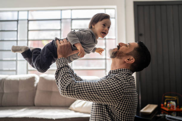 szczęśliwy ojciec bawi się z synem ze specjalnymi potrzebami w domu - father fathers day baby child zdjęcia i obrazy z banku zdjęć
