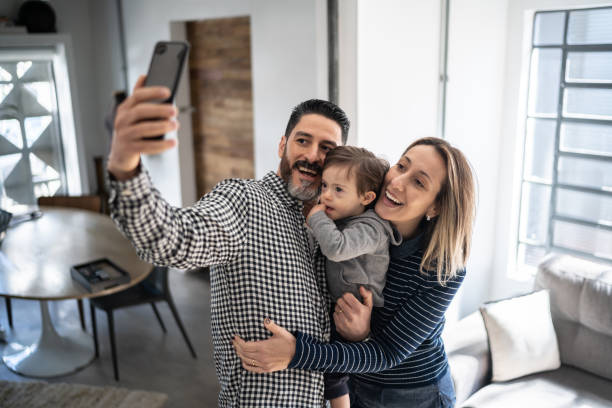 istock Family taking a selfie or doing a video call on mobile phone at home - boy with special needs 1332111716