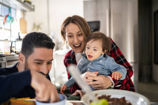 istock Parents feeding baby son or making chocolate with special needs at home 1332112237