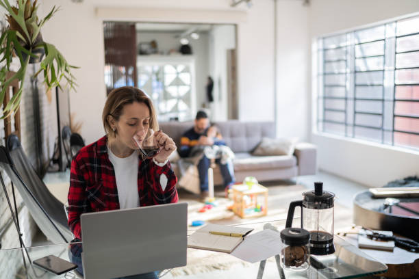 istock Mature woman drinking coffee while working at home 1332112238