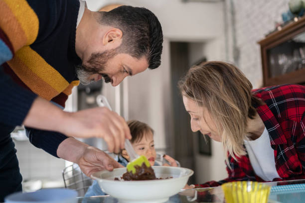 istock Parents feeding baby son or making chocolate with special needs at home 1332112273