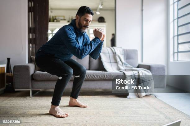 Mature Man Squatting At Home Stock Photo - Download Image Now - Exercising, Squatting Position, Relaxation Exercise