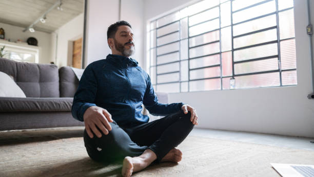 istock Mature man meditating at home 1332113507