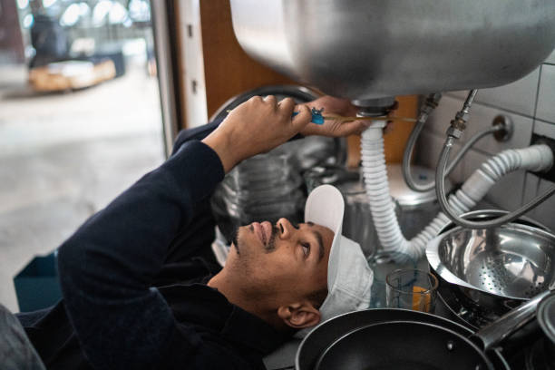 Pumber fixing water pipe under the sink