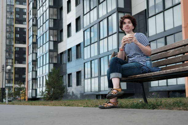 istock Woman is taking a break on bench in the city 1332113716