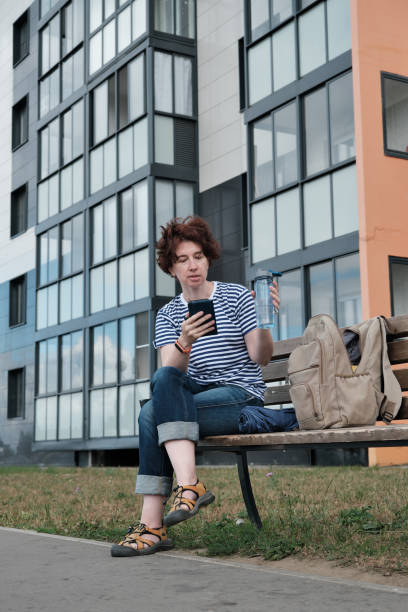 istock Woman is taking a break on bench in the city 1332113938