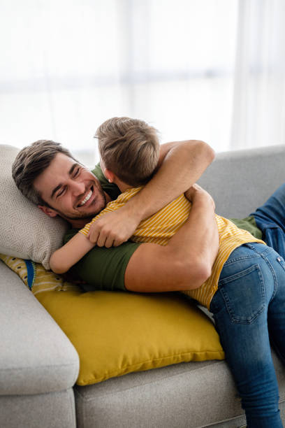 istock Cheerful young boy having fun with father together at home 1332115071