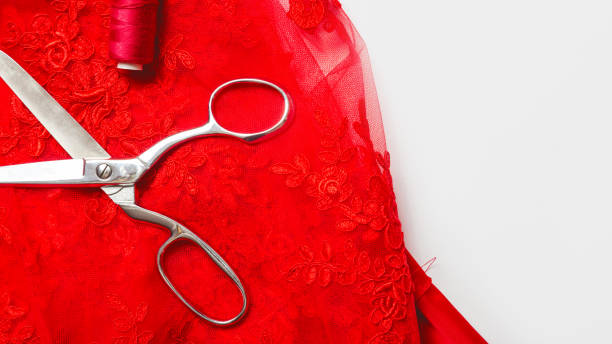 istock Sewing concept. Clothing designer workplace. Red fabric, thread and scissors on white background top view space for text 1332115890