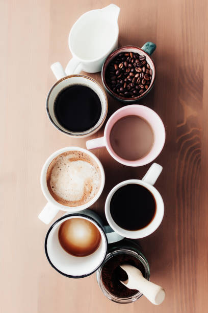istock Multiple coffee cups, milk, beans and ground coffee in jar on wooden background 1332117048