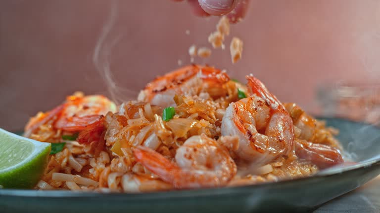 SLO MO Sprinkling peanuts onto shrimp risotto