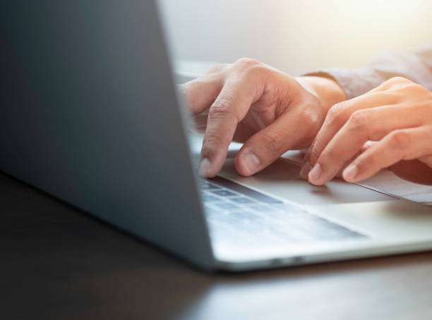 istock Close-up of man hands using and typing keyboard of laptop computer on office desk. 1332118348