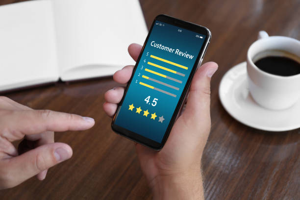 istock Man using smartphone to give feedback at table, closeup. Customer review 1332121786