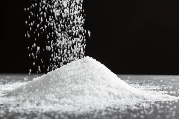 istock Scattered sugar on a black background close up 1332125320