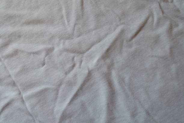 istock Surface of crumpled simple white cotton jersey fabric from above 1332125376