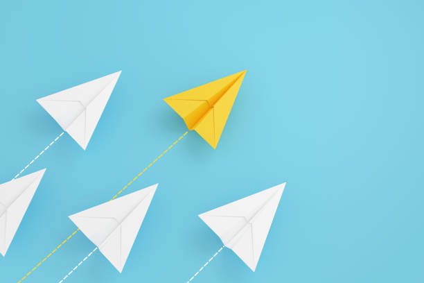 istock paper planes on aline and one is leading, isolated on blue background, concept teamwork, leadership and management. 1332125877