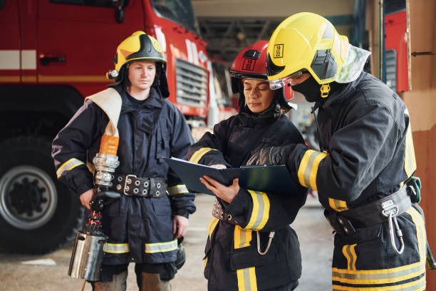 istock With notepad. Group of firefighters in protective uniform that is on station 1332126885