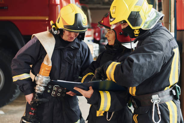 istock With notepad. Group of firefighters in protective uniform that is on station 1332126895