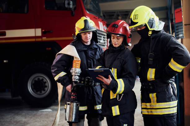 istock With notepad. Group of firefighters in protective uniform that is on station 1332126945