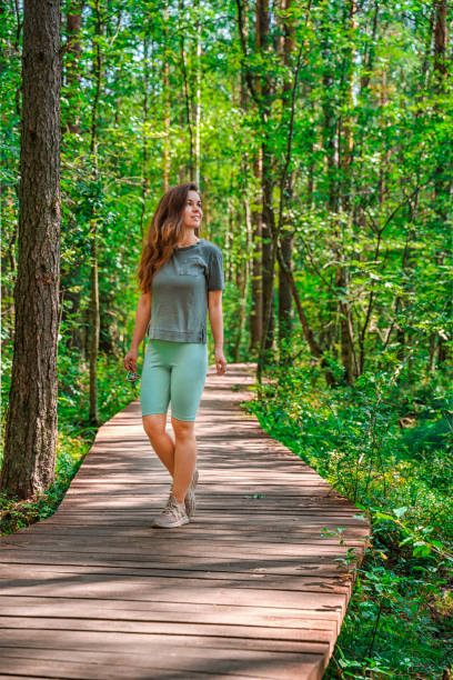 istock A young athletic woman walks through a pine summer forest 1332129409