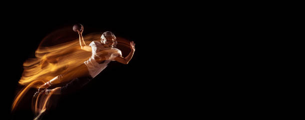 istock Flyer with young man, American football player training isolated on dark studio background with mixed neon light. Concept of sport, competition and beauty 1332130655