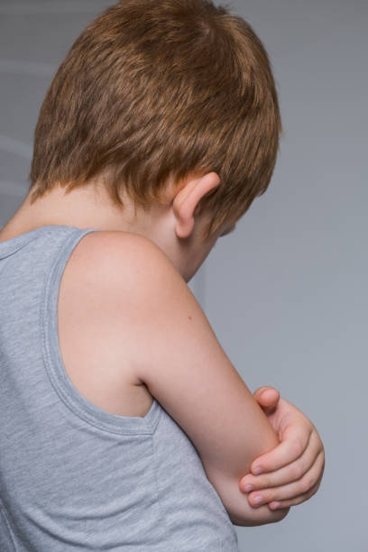 Portrait of annoyed and unhappy caucasian kid with crossed arms back. Upset and angry child concept for family relations, social problems issues and juvenile psychology stock photo