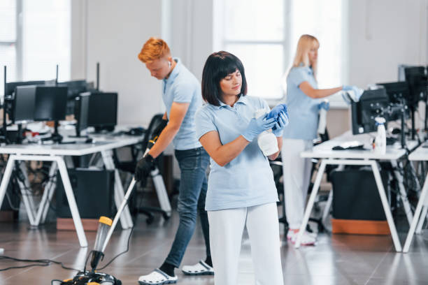 istock Cleans floor. Group of workers clean modern office together at daytime 1332137769