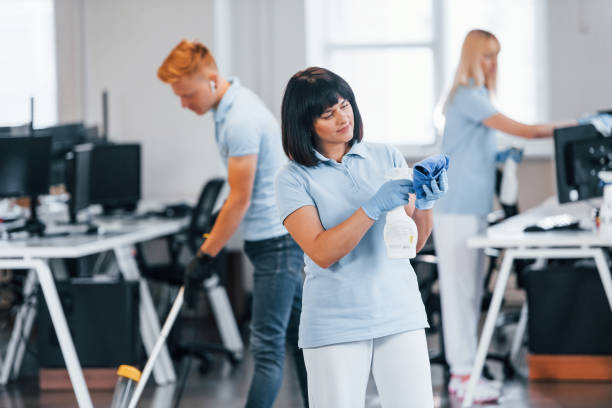 istock Cleans floor. Group of workers clean modern office together at daytime 1332137894
