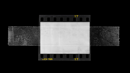 cool photo placeholder, real macro photo of 35mm film strip fixed by tape or sellotape all over the empty frame window
