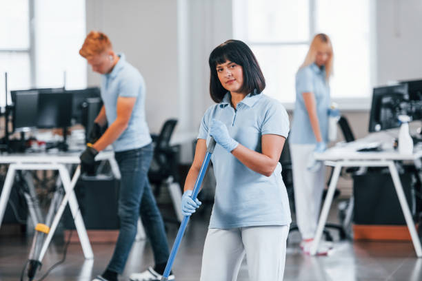 istock Group of workers clean modern office together at daytime 1332138487