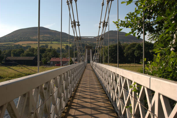 shadows on chainbridge over river Tweed and Eildon hills