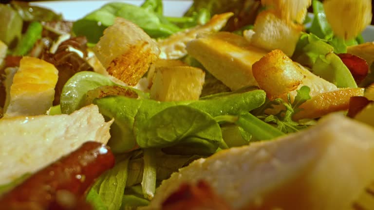 SLO MO LD Croutons falling onto a green salad with chicken strips