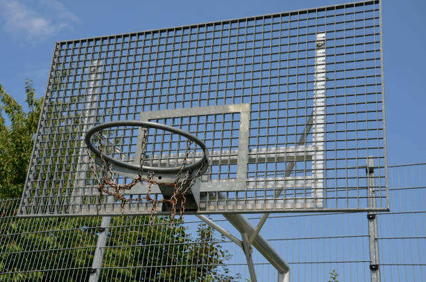 multifunctional outdoor playground for ball games at school. green artificial turf from a plastic carpet with lines. basketball hoops and soccer goals. around the grabbing high net and guardrails patio de recreo al aire libre multifuncional para juegos de pelota en la escuela. césped artificial verde de una alfombra de plástico con líneas. aros de baloncesto y goles de fútbol. alrededor de la red alta que agarra y de los barandillas
