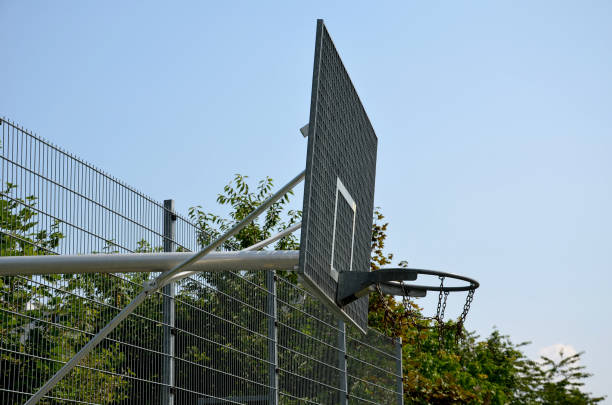 multifunctional outdoor playground for ball games at school. green artificial turf from a plastic carpet with lines. basketball hoops and soccer goals. around the grabbing high net and guardrails patio de recreo al aire libre multifuncional para juegos de pelota en la escuela. césped artificial verde de una alfombra de plástico con líneas. aros de baloncesto y goles de fútbol. alrededor de la red alta que agarra y de los barandillas