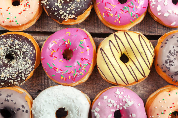 istock Glazed donuts on wooden background 1332146215