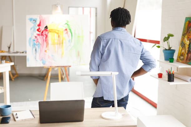 istock African american male painter at work looking at artwork in art studio 1332147919