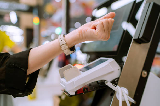 Customer self checkout and using contactless payment. Asian woman using smartwatch for contactless paying at department store. self checkout stock pictures, royalty-free photos & images