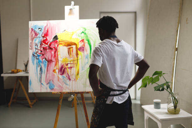 istock African american male painter at work looking at artwork in art studio 1332149139