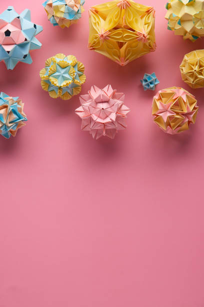 conjunto de bolas modulares multicoloridas ou kusudama isoladas no fundo rosa. arte visual, geometria, arte de dobrar papel, artesanato de papel. vista superior, close-up, foco seletivo, espaço de cópia. - kusudama - fotografias e filmes do acervo