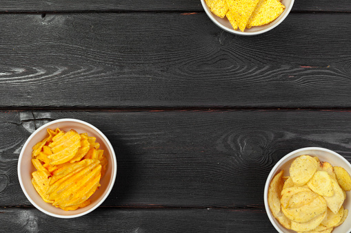 Bowls with tasty crispy potato chips